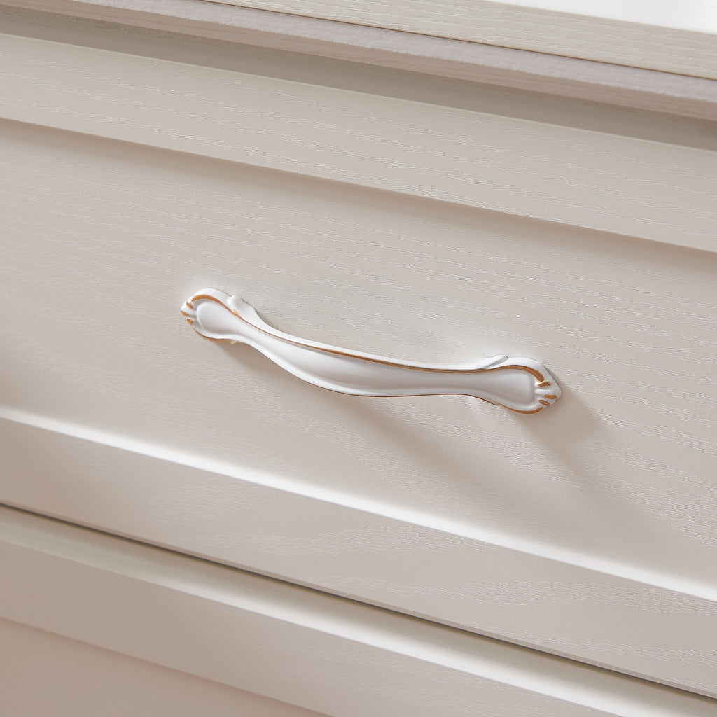 Close-up of a white dresser drawer with a chrome metal bar pull