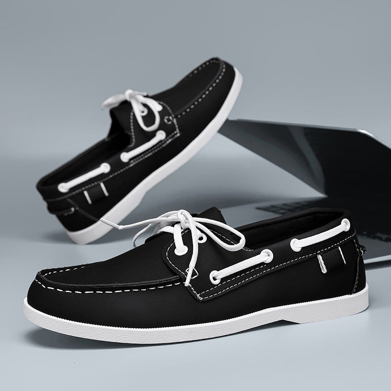 Men's black loafer shoes with white laces, white stitching, and white sole