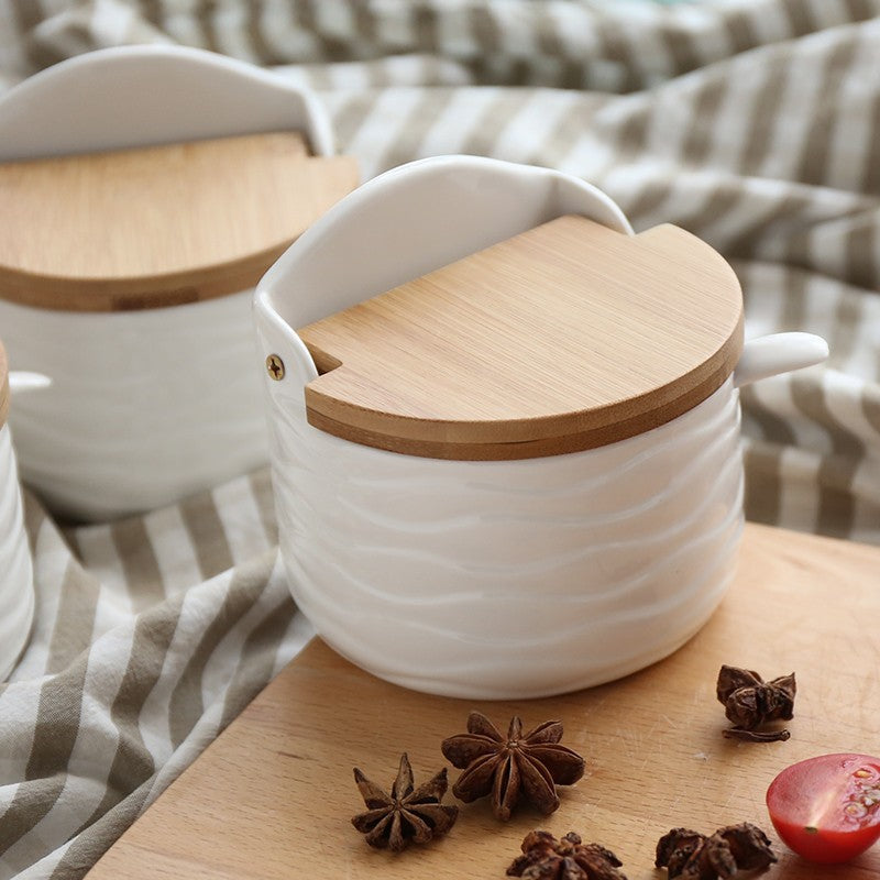 Half-round white ceramic seasoning can with light wood flip-top lid