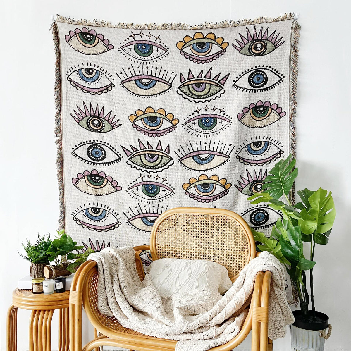 Evil eye blanket with all-over eye pattern, green accents, and fringed edge