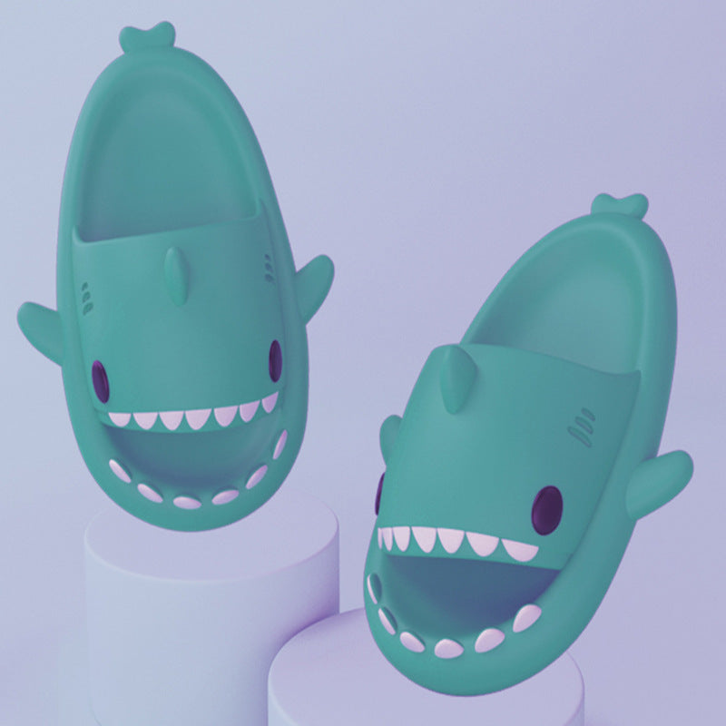 Teal shark-shaped slide sandals on pedestal bases, open toe with white teeth