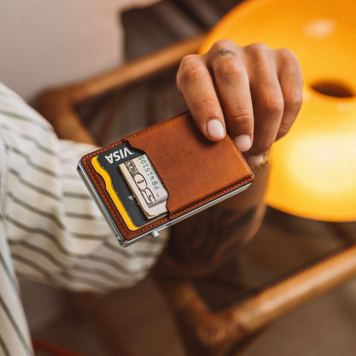 Brown leather cardholder wallet with cards and ID window, metal frame detail