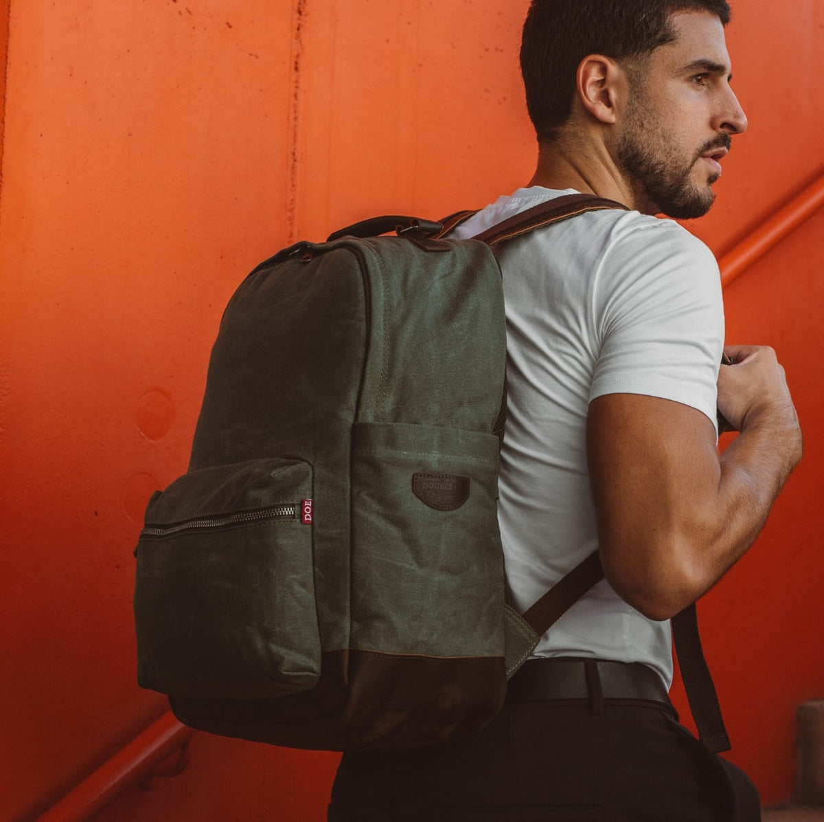 Dark green backpack with front pockets and webbed shoulder straps