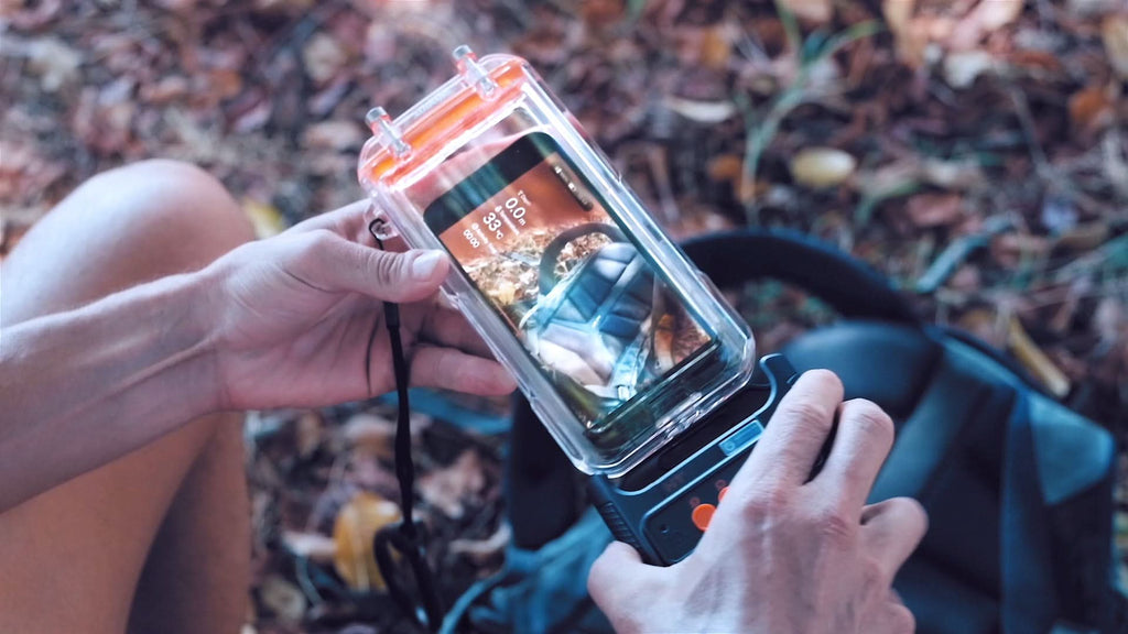 Hands holding a clear waterproof phone case with phone inside and protective seal.