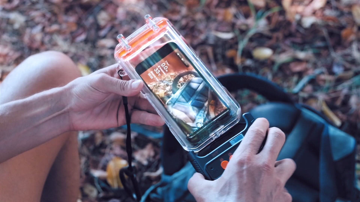 Hands holding a clear waterproof phone case with phone inside and protective seal.