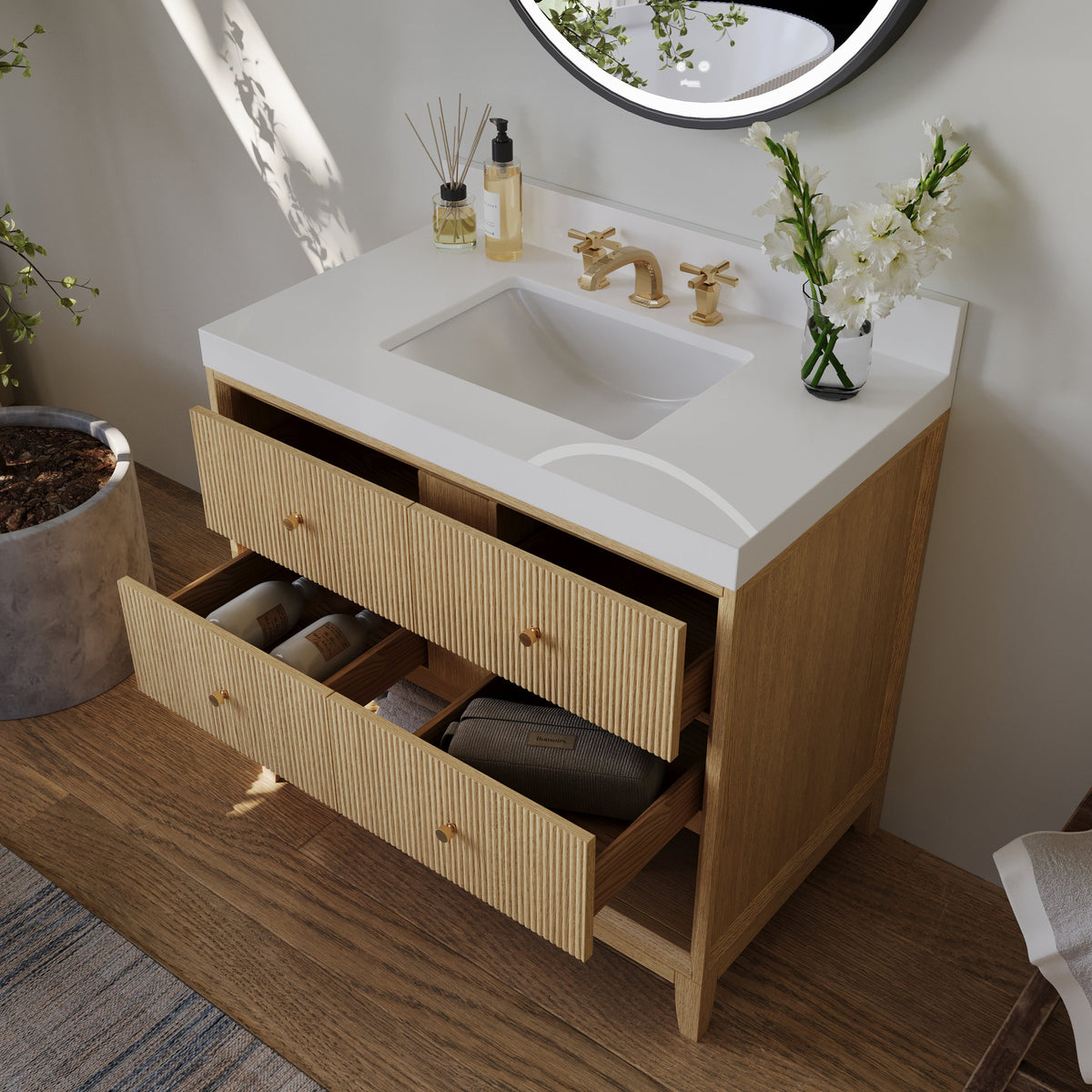 Oak bath vanity set with pull-out storage drawers and white sink basin, gold faucet
