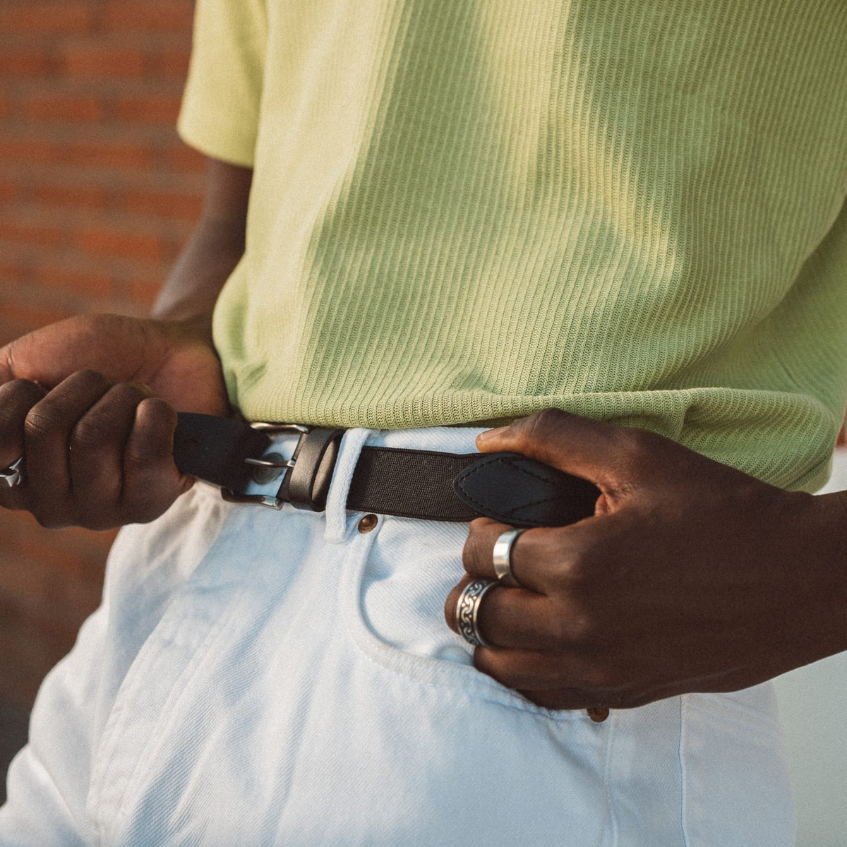 Black leather stretch belt with silver buckle and stitched keeper strap
