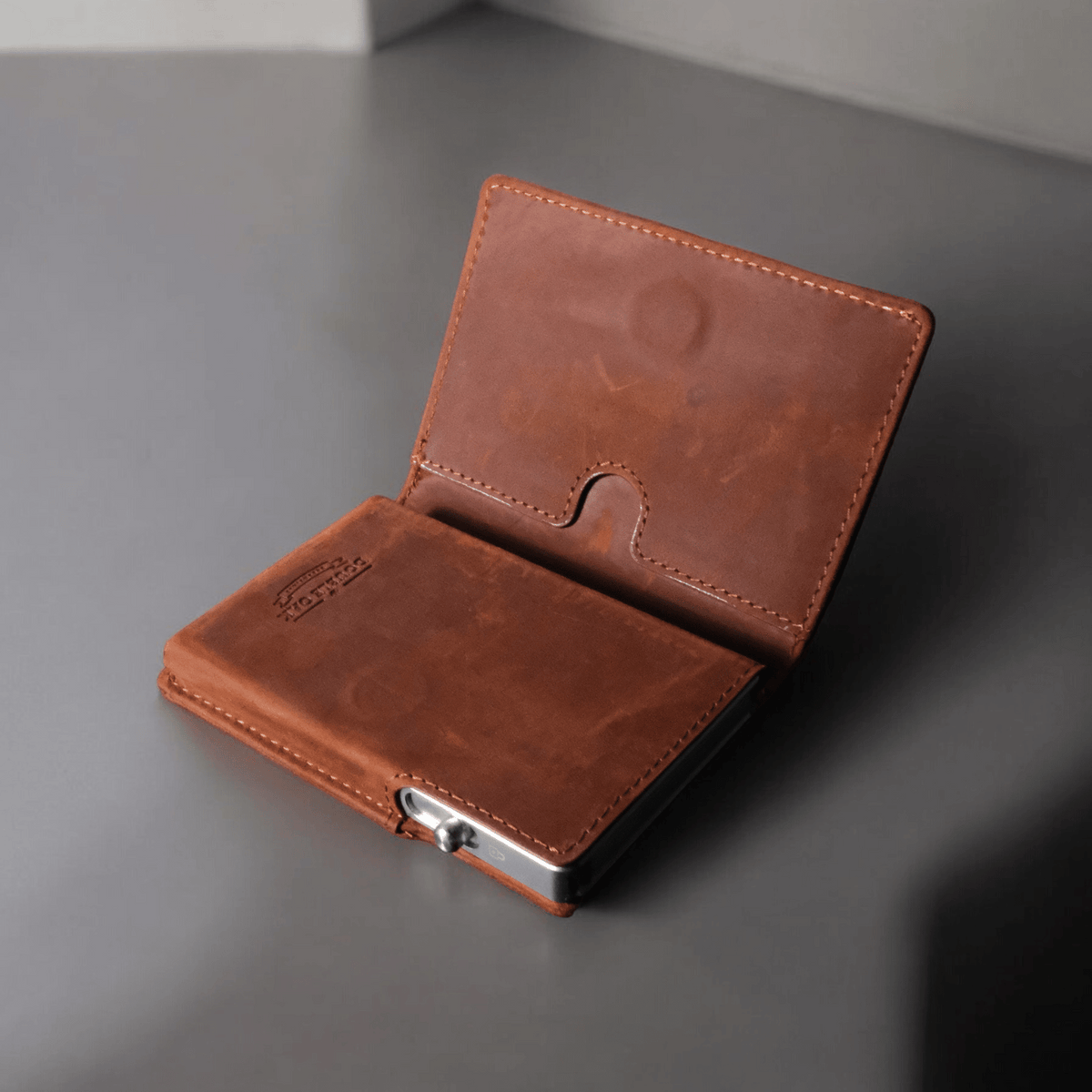 Brown leather bifold wallet open with snap clasp and card slots
