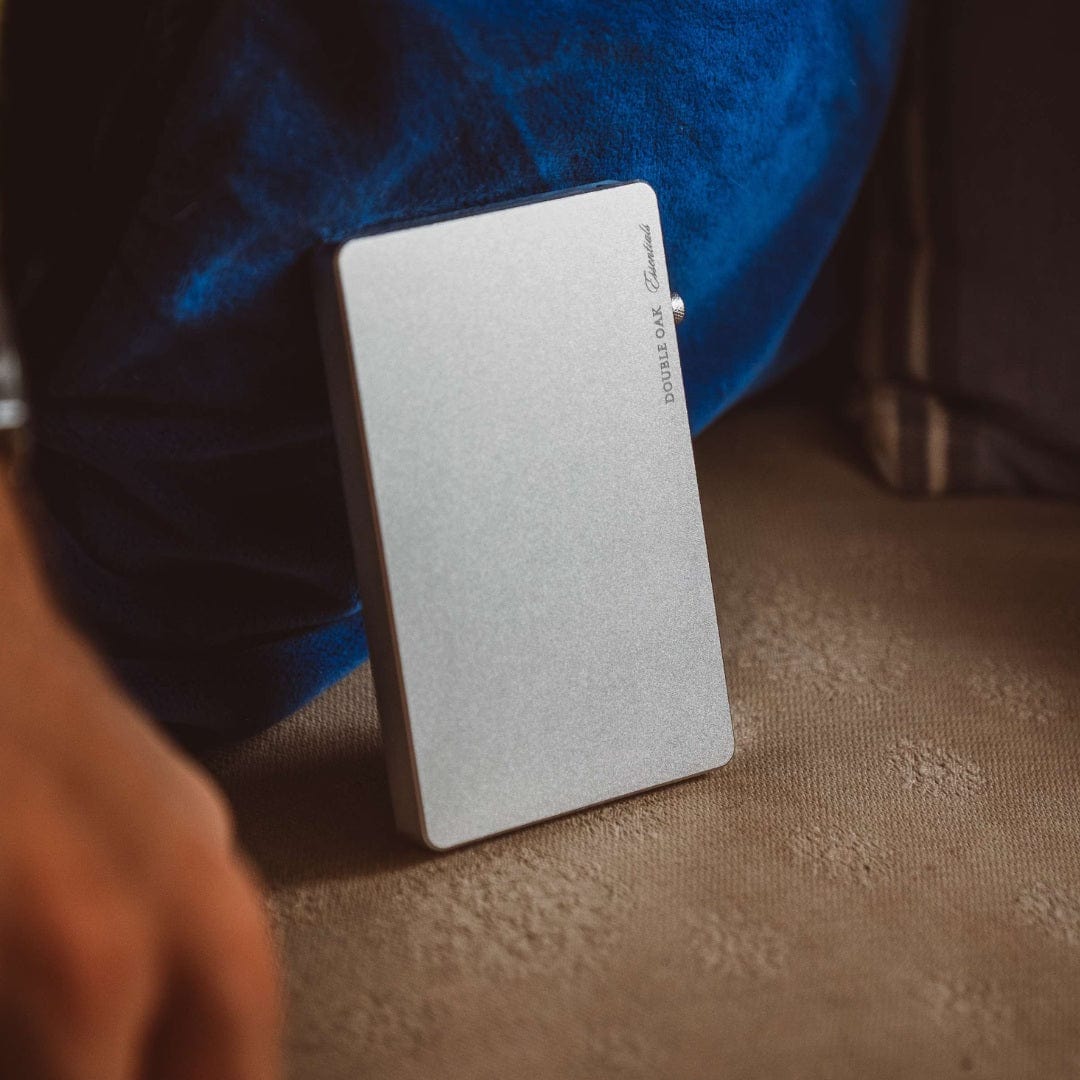 Silver pop-up cardholder held upright, smooth front panel and logo.