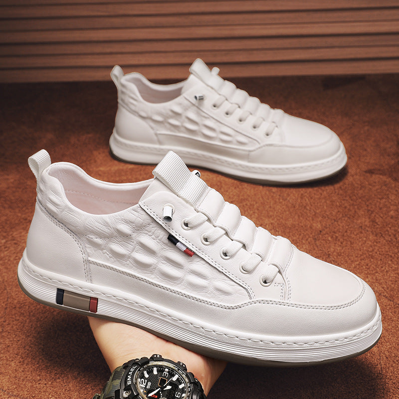 White leather-look lace-up sneakers with textured upper and striped sole trim.