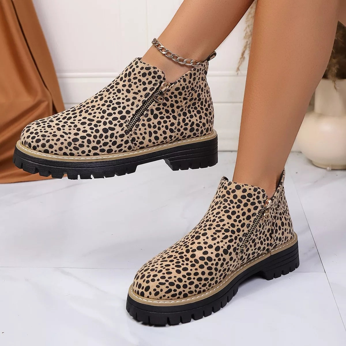 Leopard print ankle boots with side zipper and chain ankle strap, angled view