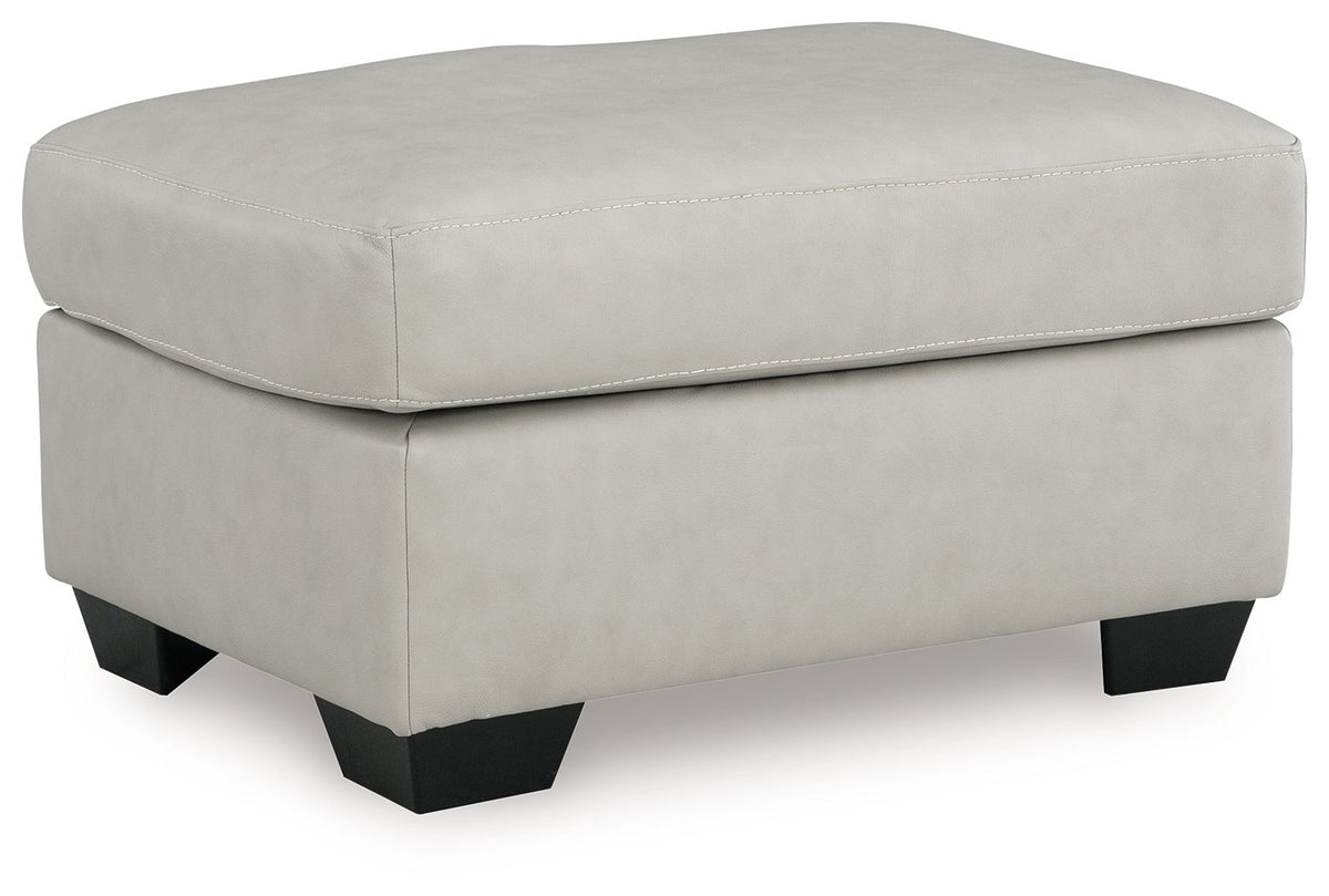 Light gray padded ottoman with stitched top seam and black square tapered legs