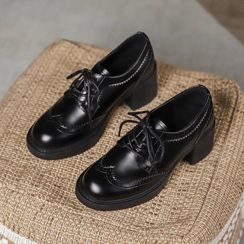 Black lace-up leather-style shoes with round toe, chunky heel, and stitched detailing.