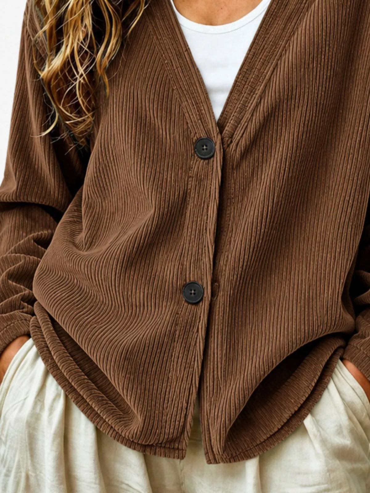 Brown corduroy button-up cardigan close-up with black buttons and V-neck