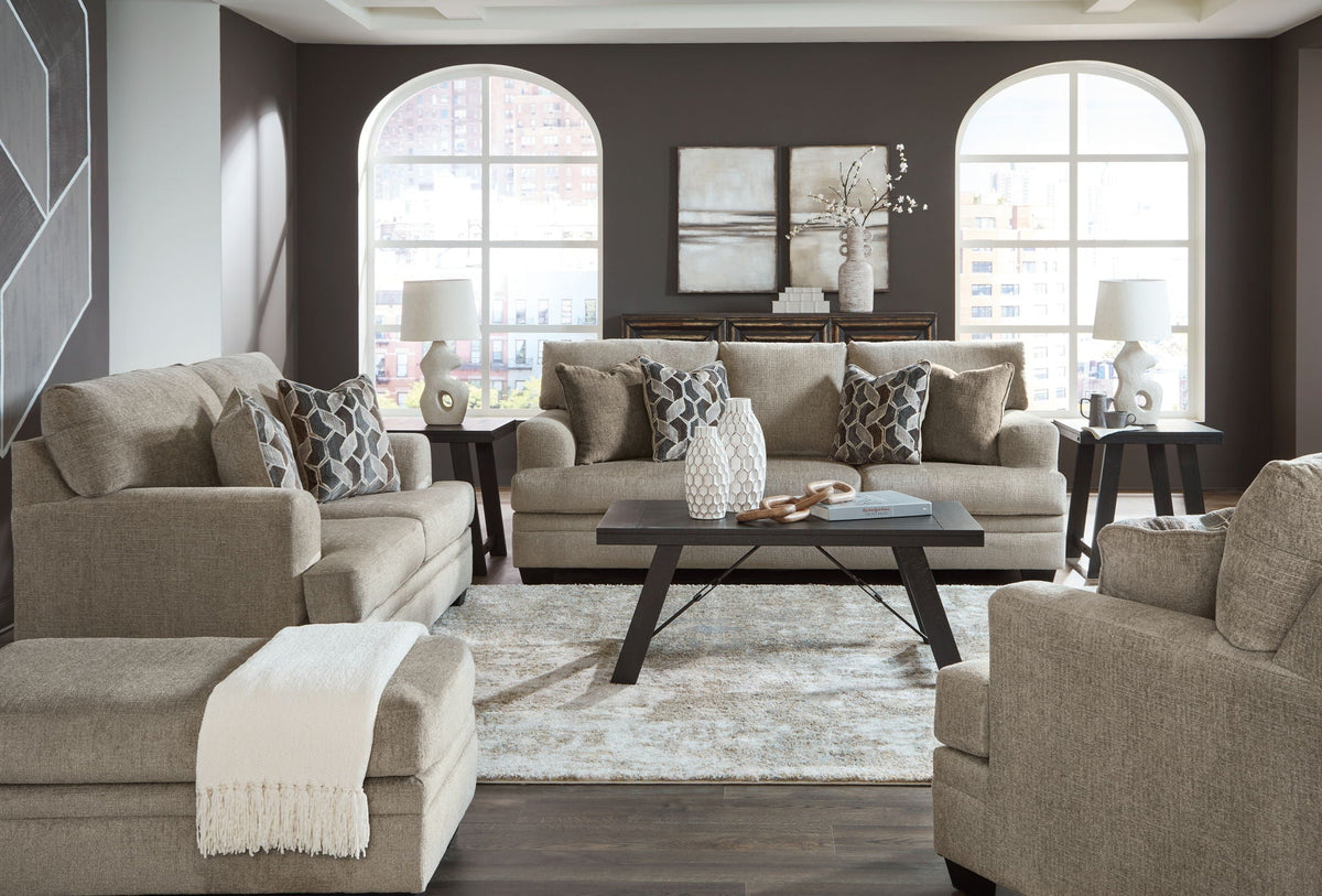 Light brown fabric living room set with sofa, loveseat, and armchairs with pillows