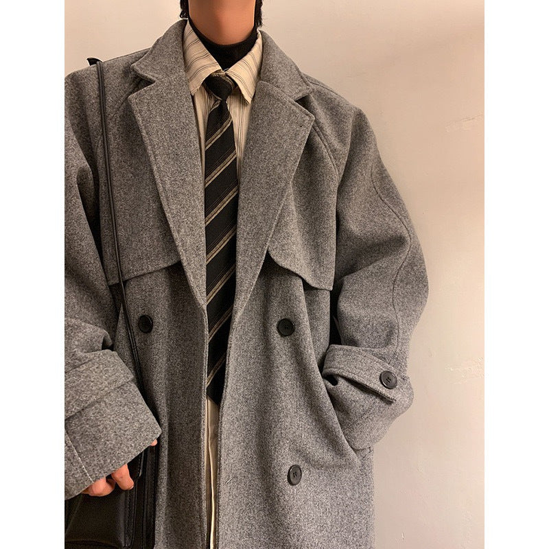 Gray mid-length wool overcoat with notched lapels, buttoned flap pockets, and sleeves