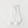 Pair of white mid-calf ribbed baby socks.