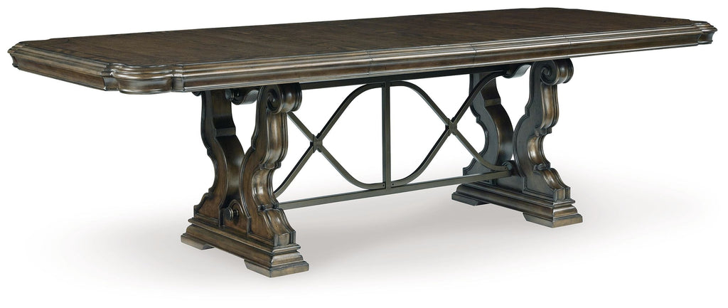 Dark brown dining extension table with ornate pedestal-style legs and X-frame support
