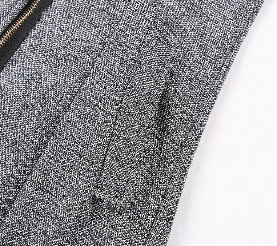 Close-up of textured dark gray wool coat fabric with visible zipper edge