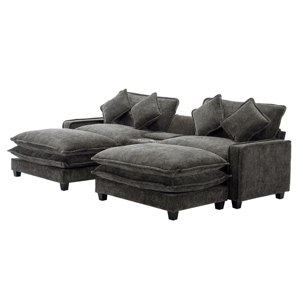 Dark gray sectional sofa with stacked ottoman seats and several back throw pillows