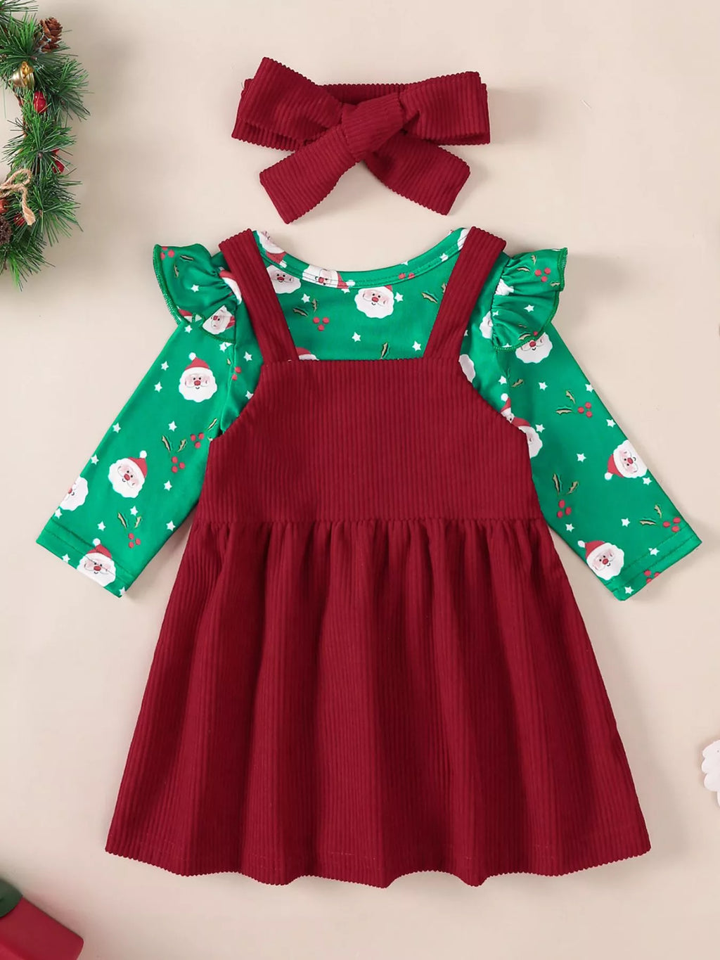 Burgundy pinafore-style dress over green Santa-print bodysuit with bow headband