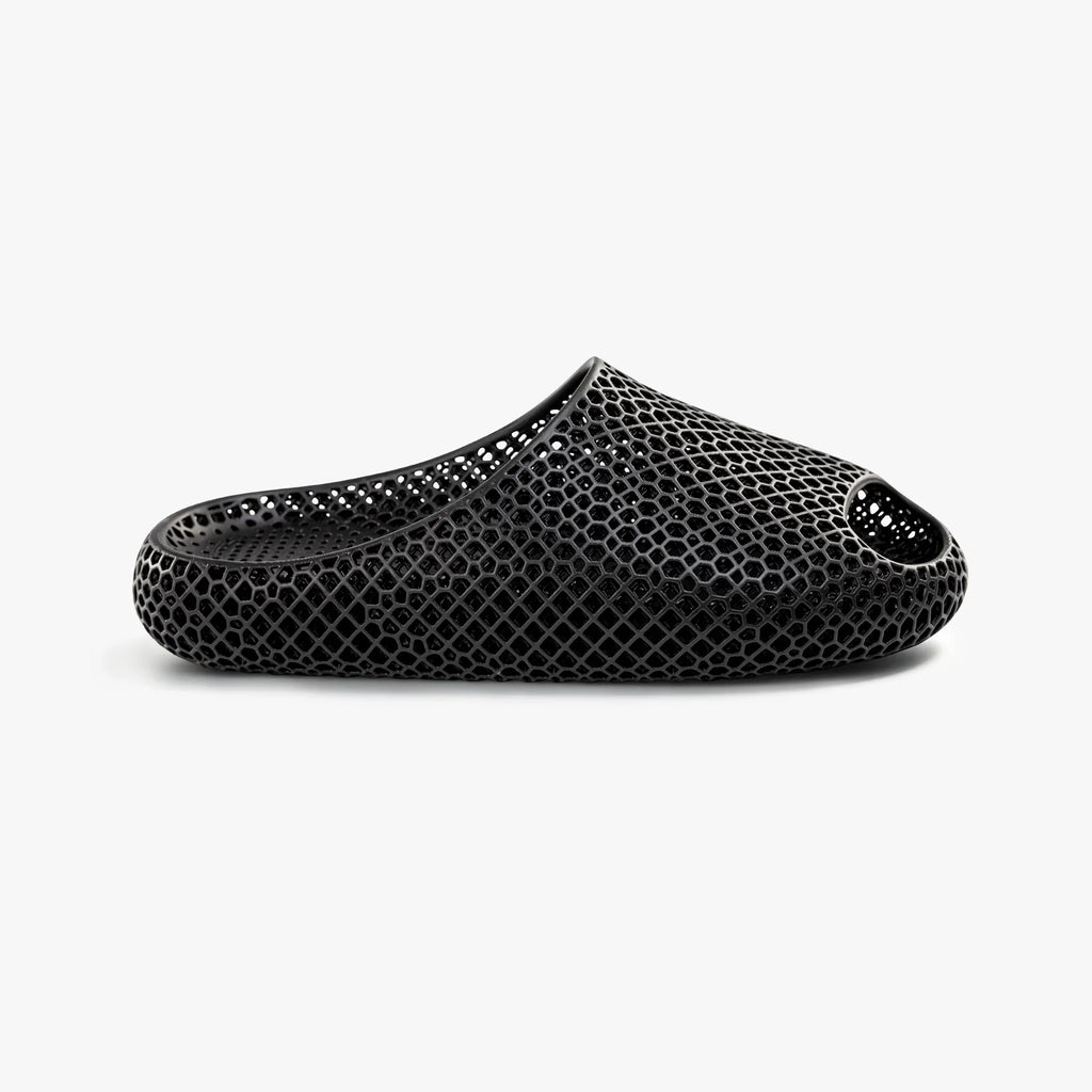Black 3D-printed mesh slip-on slippers with rounded toe and cushioned sole.