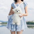 White plush puppy backpack with face detail and soft body, carried as a bag pouch