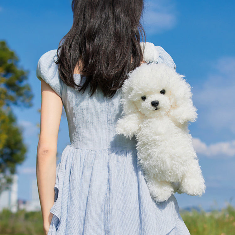 White plush puppy backpack with stitched eyes and floppy ears, worn on the back