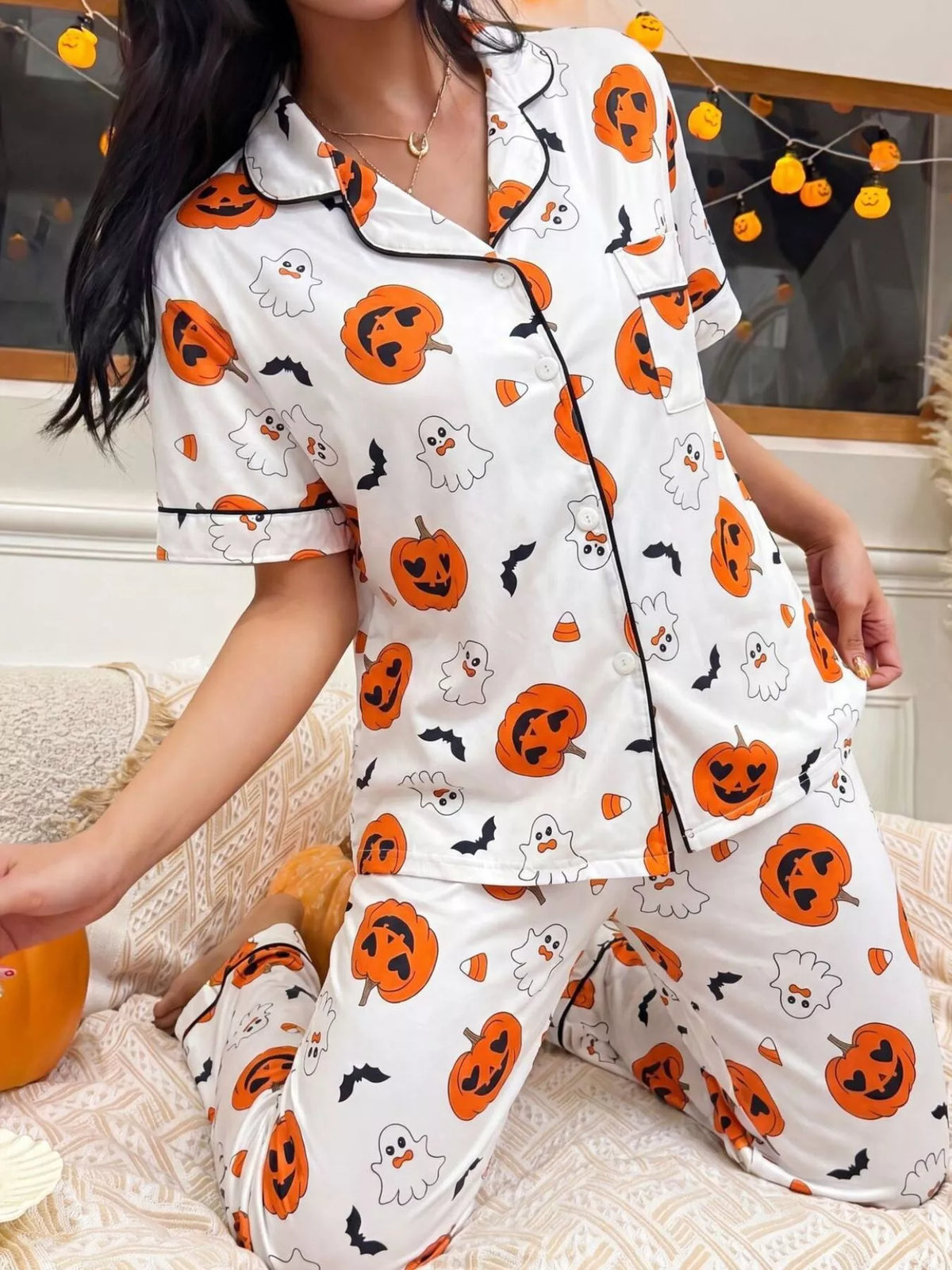 White Halloween pajama set with pumpkin and ghost motifs, button-front short-sleeve top and pants