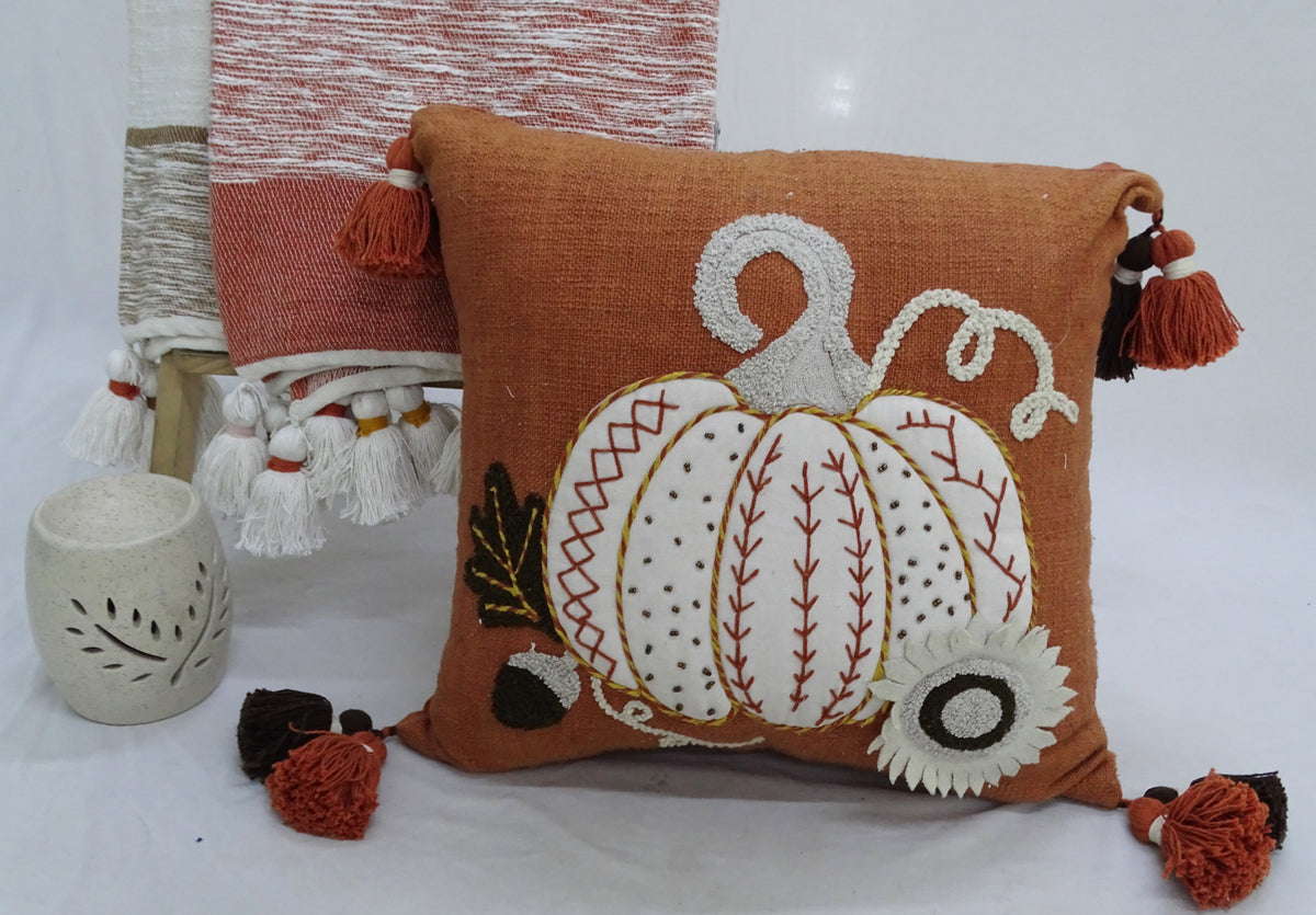 Fall pumpkin throw pillow with white-outlined pumpkin design and brown tassel trim