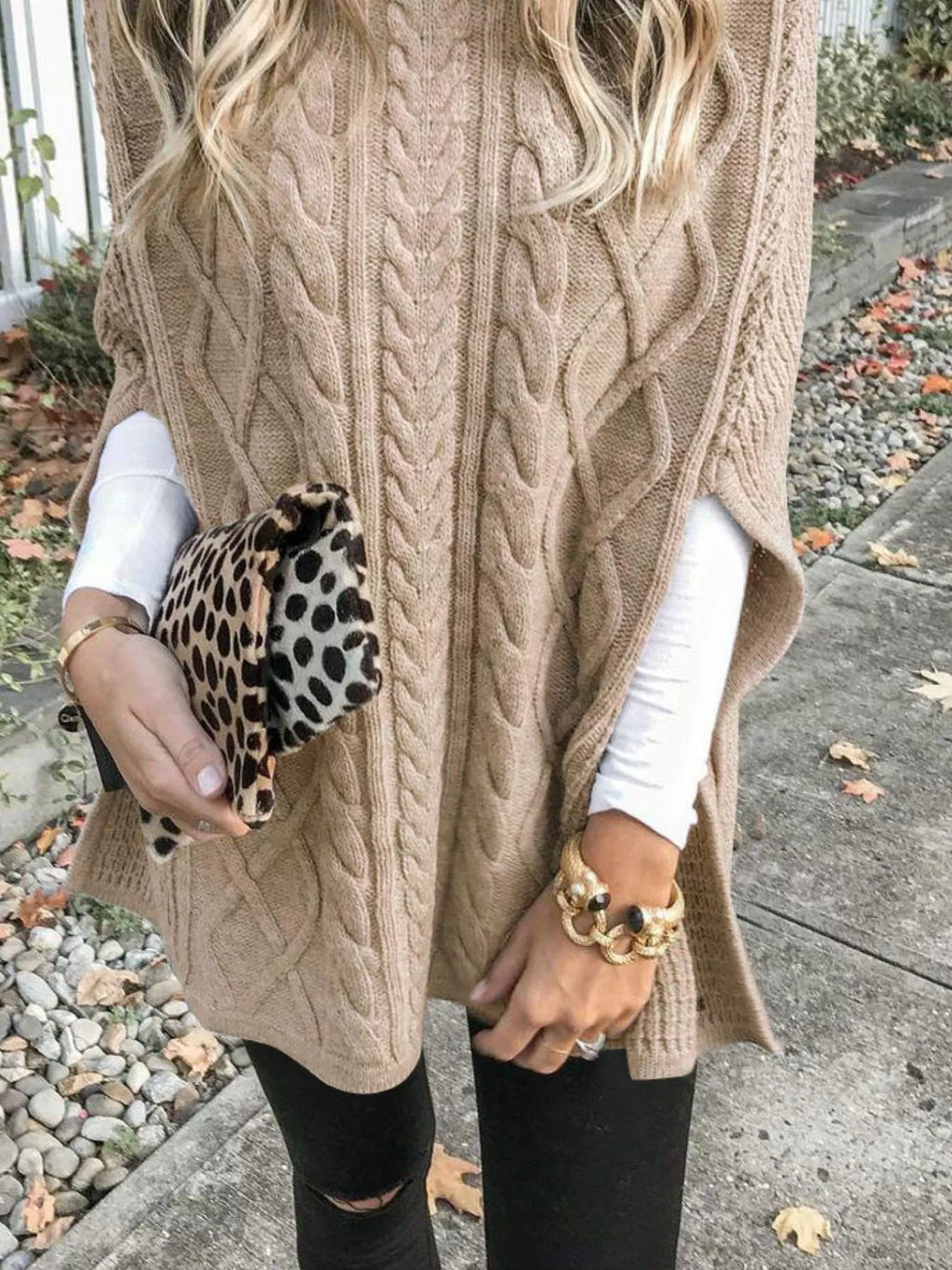 Tan cable-knit turtleneck poncho cover-up with open-knit sides and fringe hem