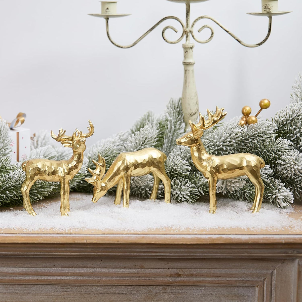 Gold resin reindeer figurines on snowy tabletop, three-piece holiday display