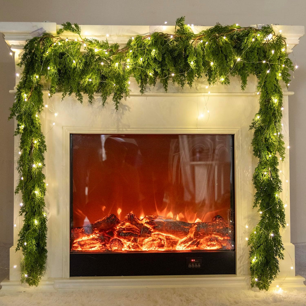 Artificial Christmas garland with pine/cypress greenery and warm LED string lights, mantel display