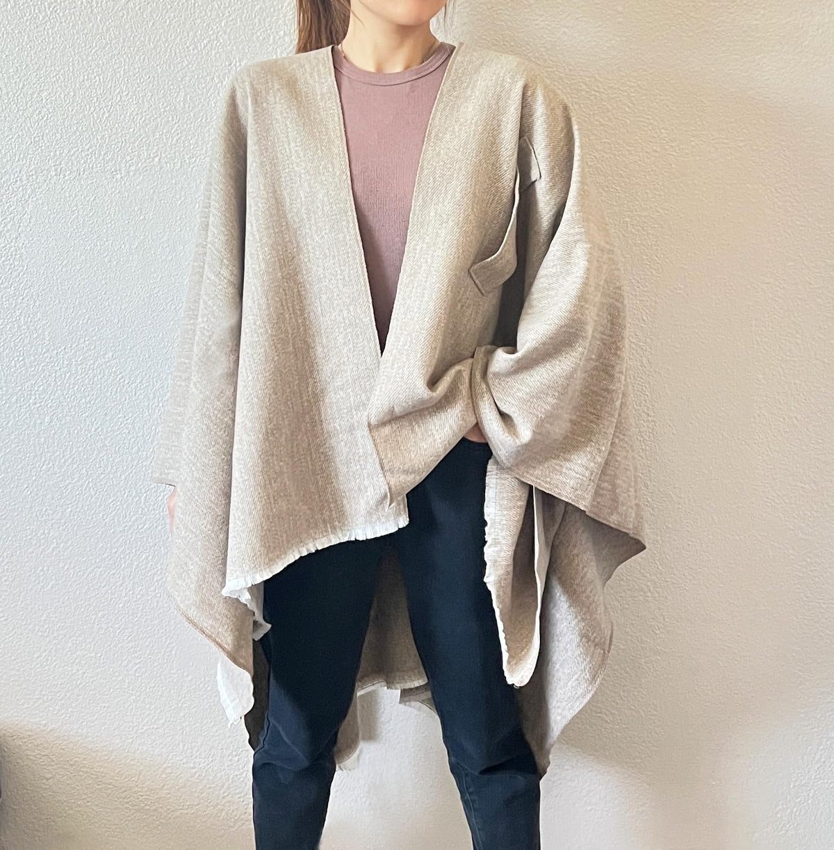 Light beige open-front fringe poncho shawl worn with tied waist knot