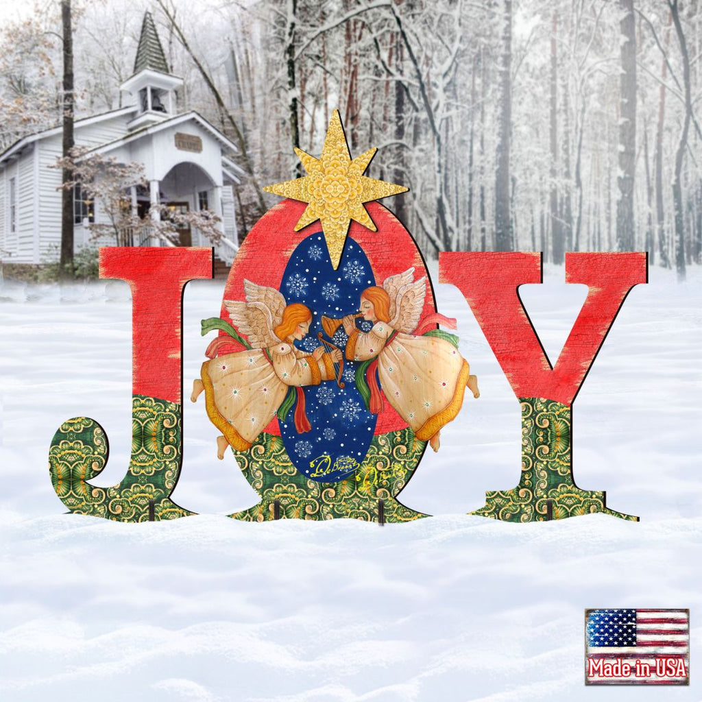 Outdoor “JOY” nativity yard decor with angels and a yellow star, red and green accents.