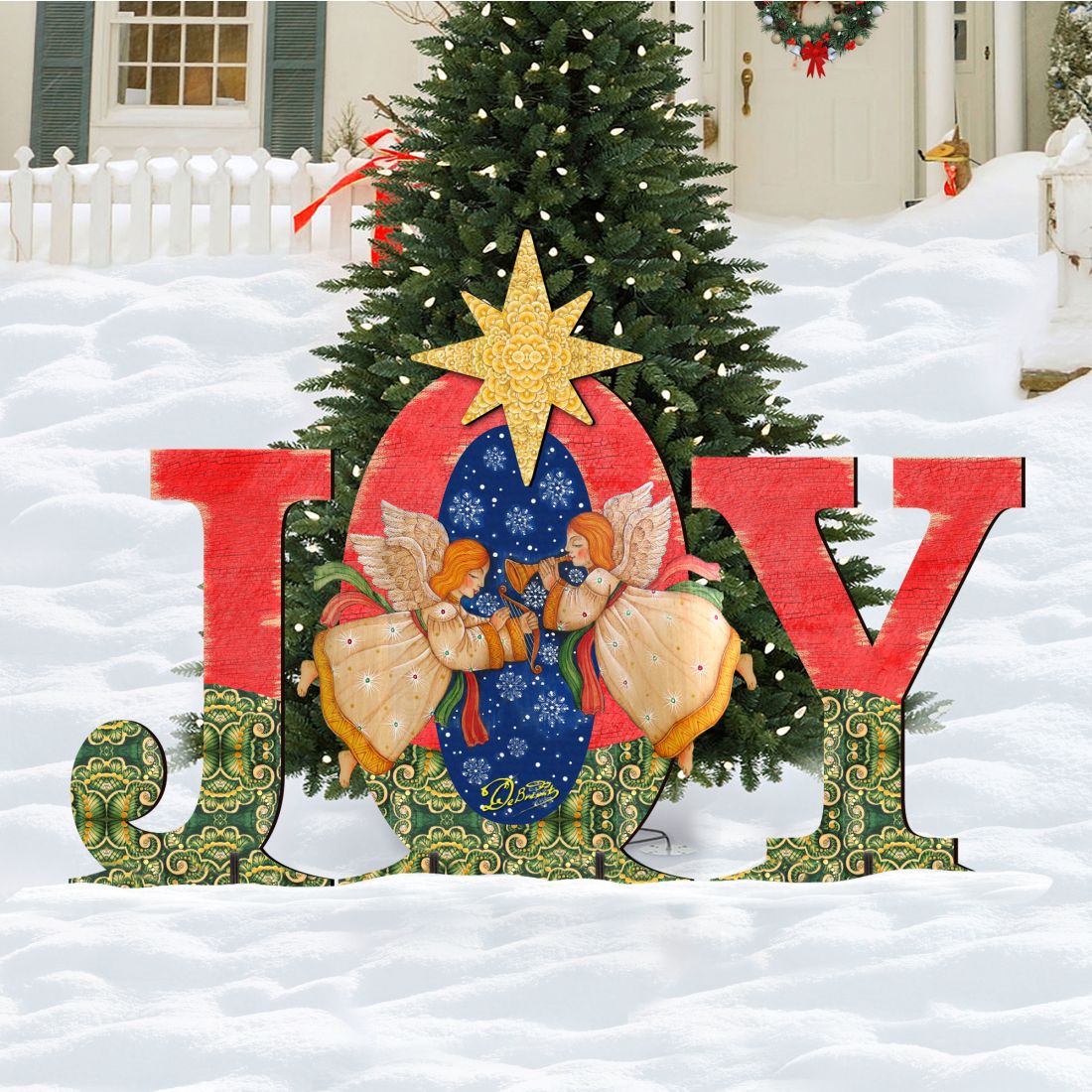 Outdoor “JOY” nativity yard decor with angels and yellow star in front of a Christmas tree.