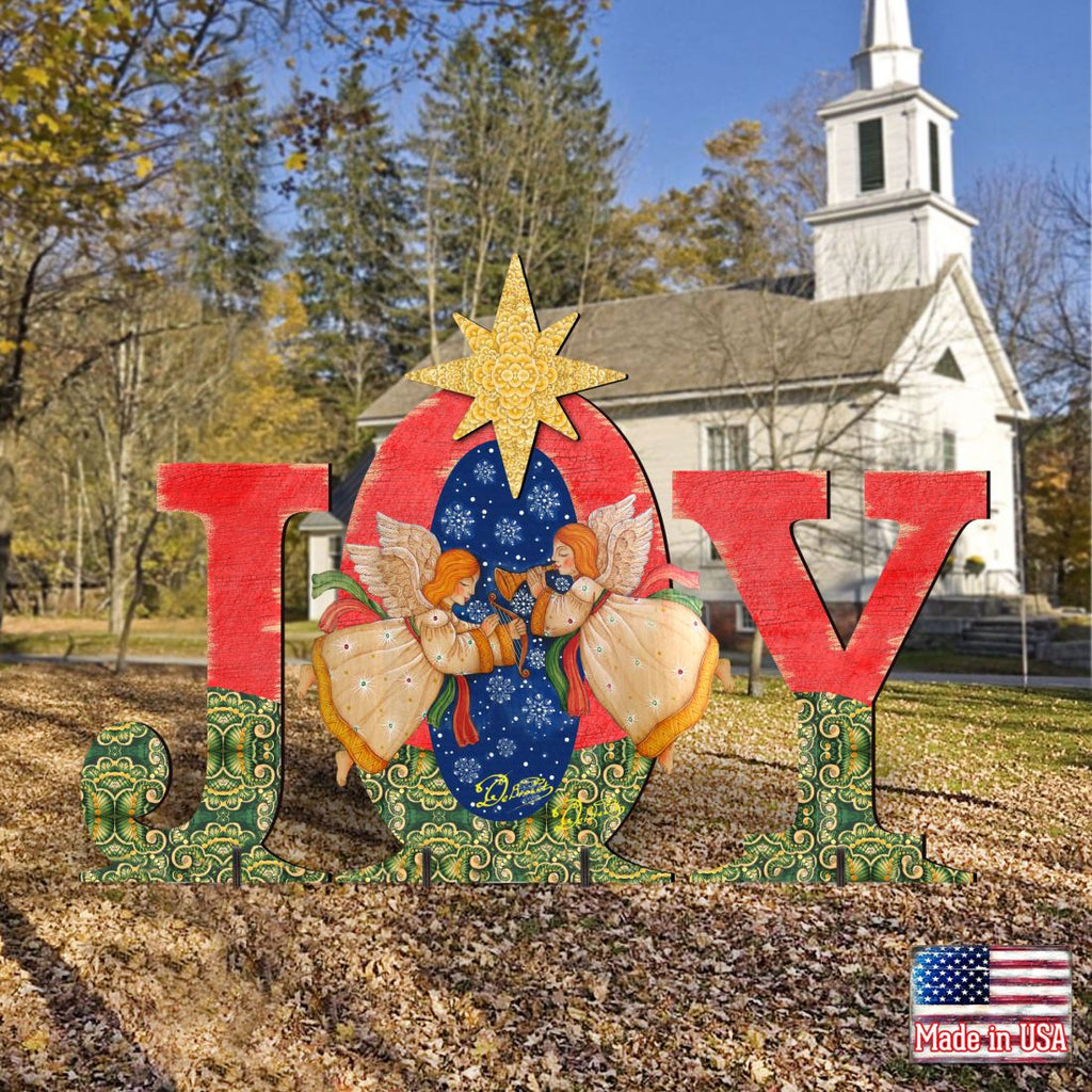 Outdoor “JOY” nativity yard decor with angels and yellow star in fall yard setting.