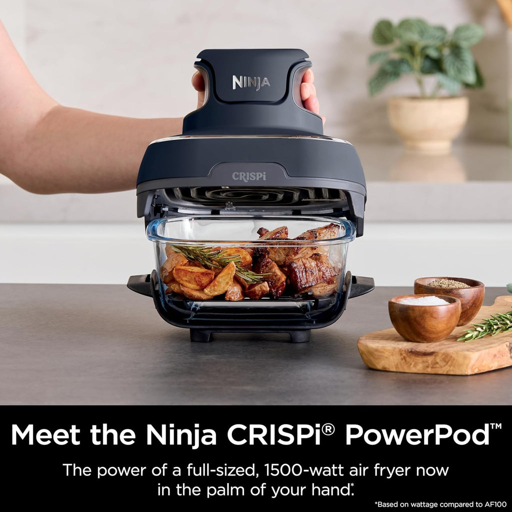 Portable air fryer base with clear glass cooking container and cooked meat on the rack