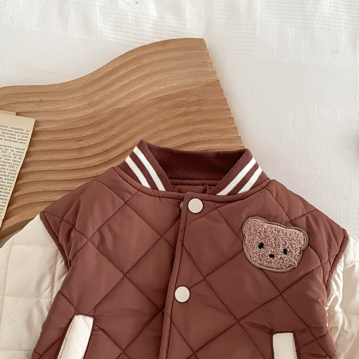 Kids reddish-brown quilted jacket with bear applique patch and striped ribbed collar