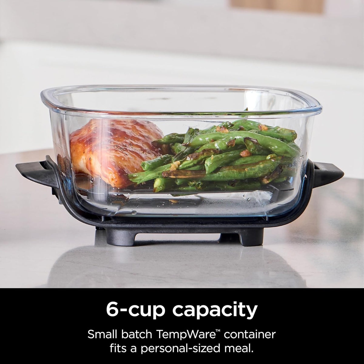 Clear 6-cup glass container filled with meal, with black leak-proof lid attached