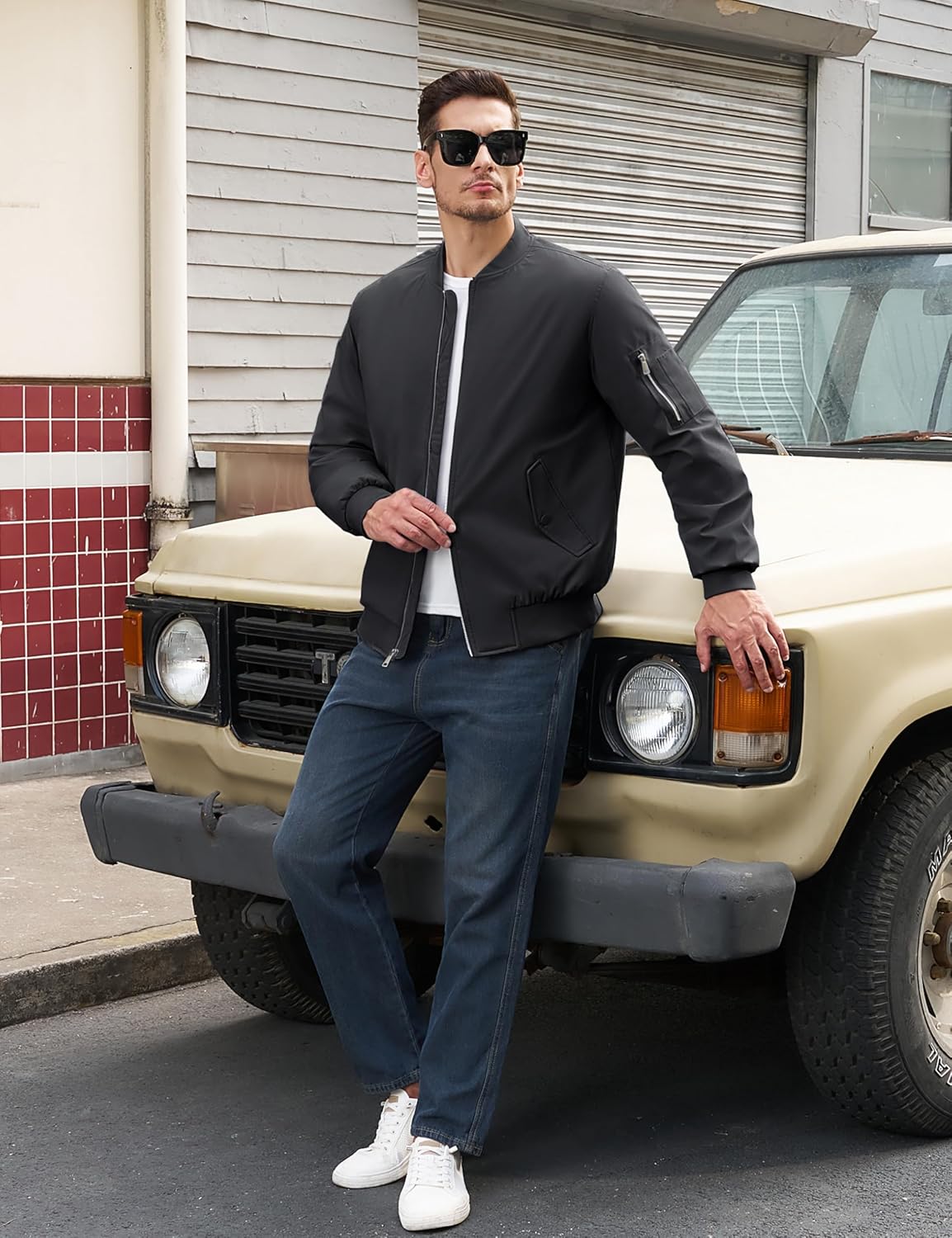 Men's black bomber jacket on model, orange quilted lining, zip pockets and full front zipper