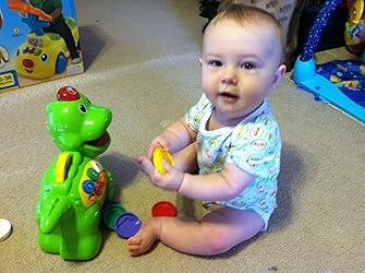 Green baby dinosaur toy with numbered wheels and interactive buttons
