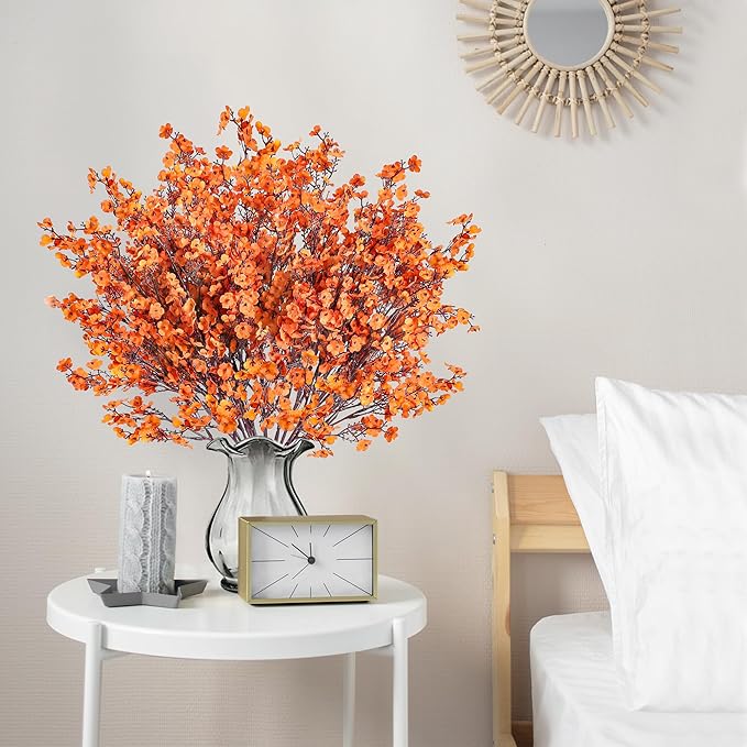 Orange artificial baby's breath bouquet in silver vase on nightstand