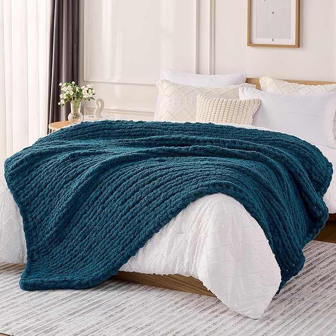Chunky cable knit chenille throw blanket, dark teal blue, draped over bed