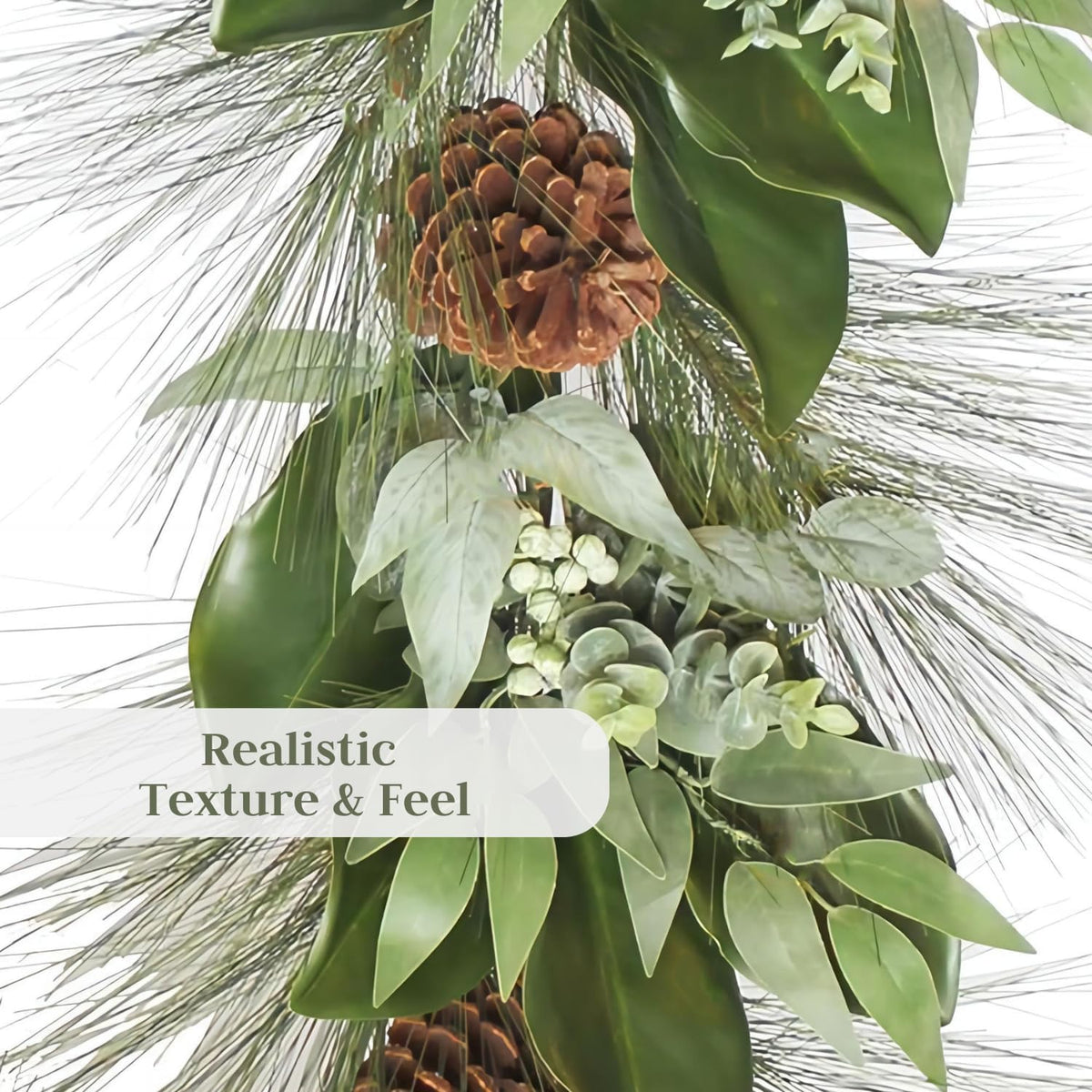 Close-up of faux garland branches with pinecones and green leaves