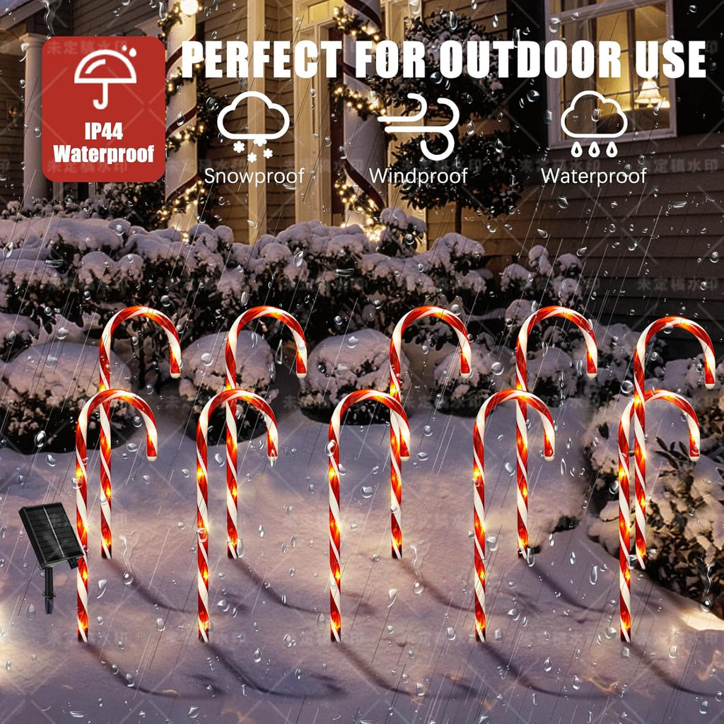 Candy cane solar pathway lights with red-white striped arches glowing outdoors in snow