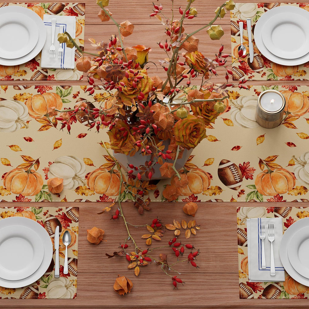 Long fall table runner with pumpkins, autumn leaves, and football motifs across table