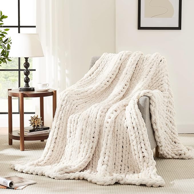 Chunky cable knit throw blanket in off-white, draped with thick braided texture