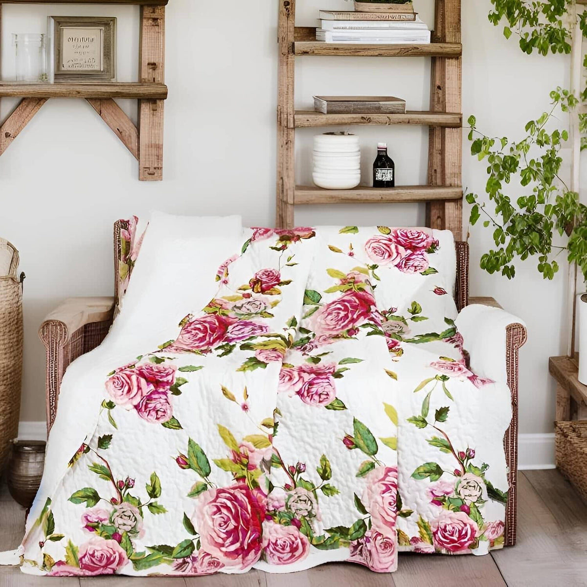 Quilted throw blanket featuring pink roses and green leaves on a white background