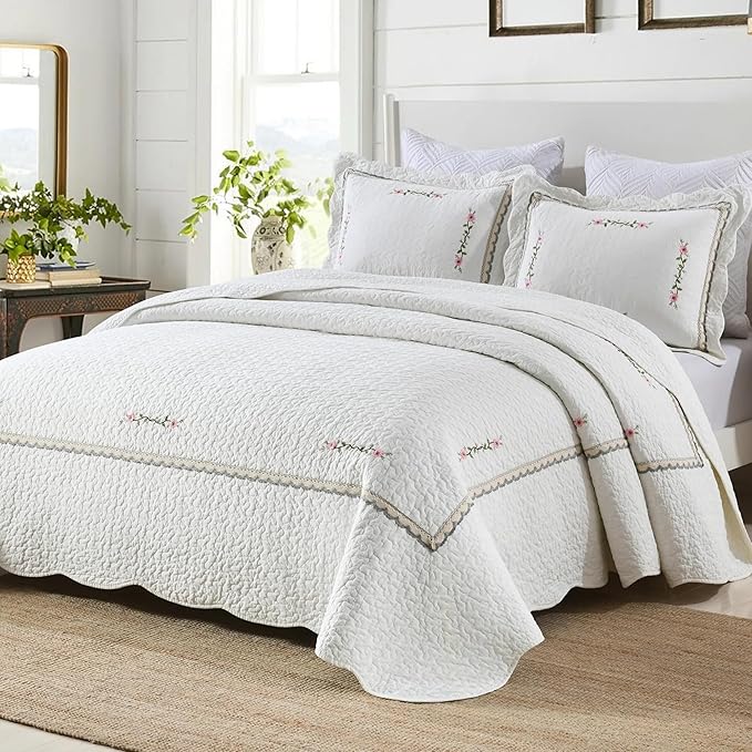 White oversized quilt coverlet with embroidered floral sprigs and stitched border
